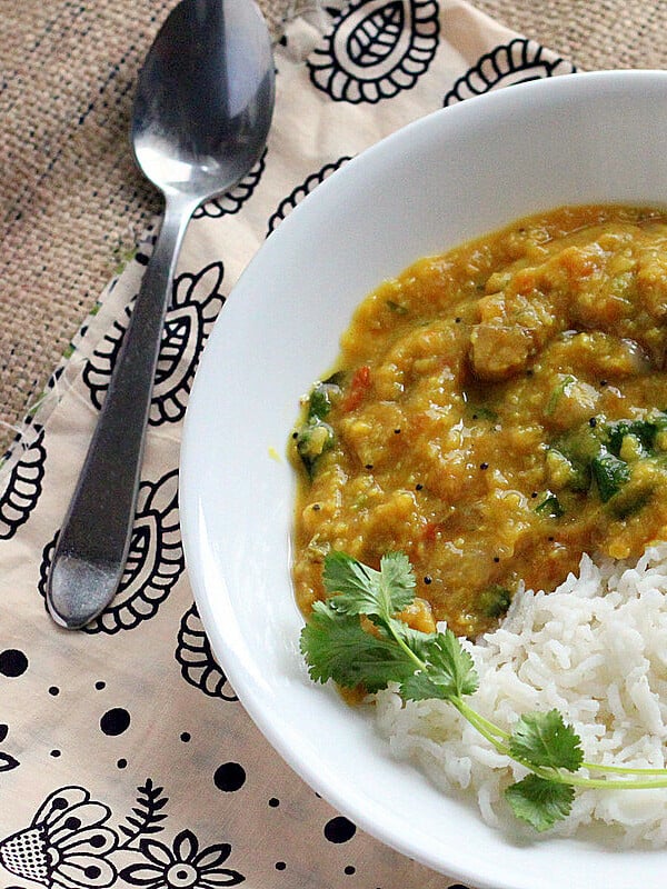 A bowl of toor daal and rice on patterned fabric