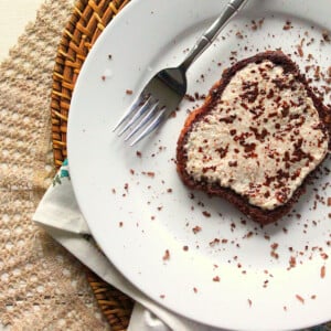 A slice of French toast on a white plate with a fork. Sprinkled with cocoa powder