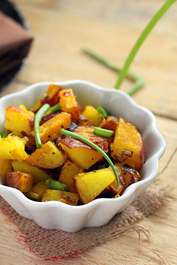 Potato Leet Subzi in a white bowl on a wooden work surface