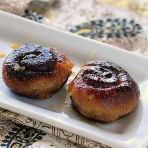 Two kala jamuns on a white plate