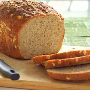 A sliced loaf of cherry amaretto bread on a wooden chopping block