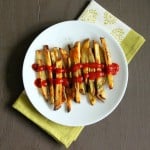 A plate of baked French fries with tomato sauce
