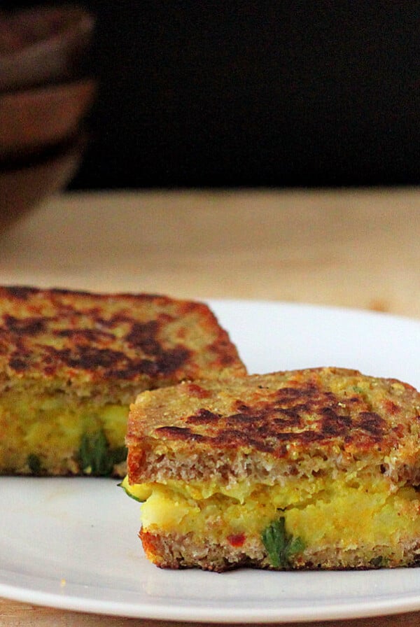 Stuffed French toasts served on a white plate and cut in half