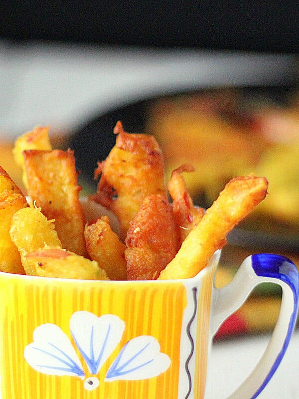Apple fritters served in a yellow and blue mug
