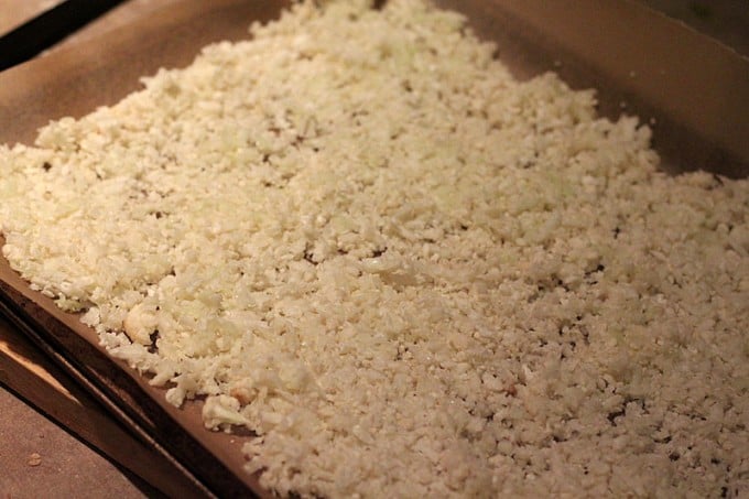 raw grated cauliflower on parchment paper