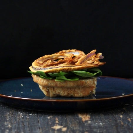 vegan burger toppings on a bun on a blue plate