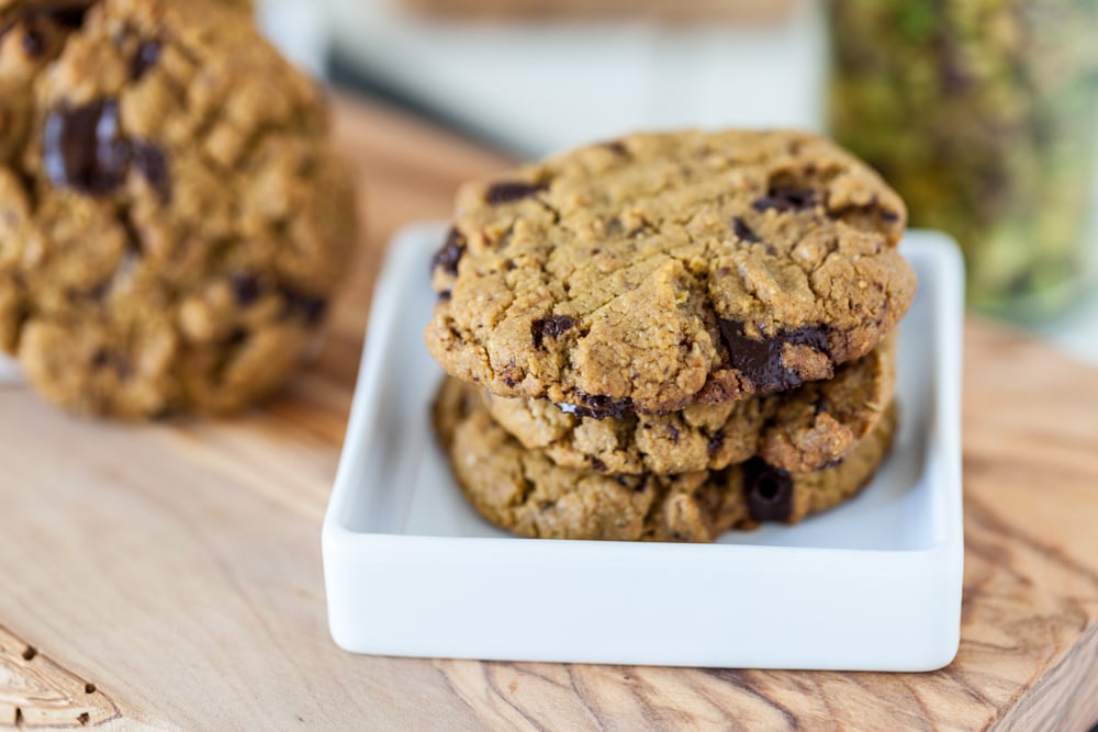 An easy Pistachio Cookies recipe with pistachio butter as the main ingredient and chocolate chunks for extra good flavor! Vegan, Gluten Free. gluten free pistachio butter cookies on small white plate on wooden board