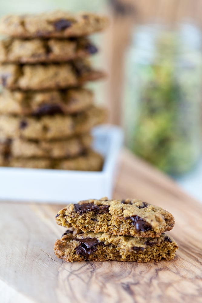 An easy Pistachio Cookies recipe with pistachio butter as the main ingredient and chocolate chunks for extra good flavor! Vegan, Gluten Free. broken vegan pistachio cookies with chocolate with stack of cookies in background