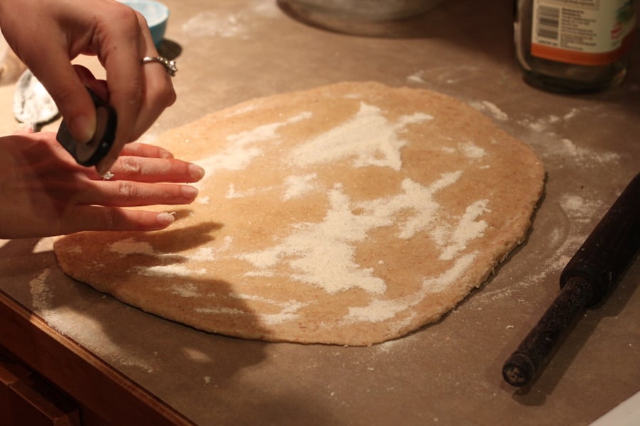 vegan cinnamon rolls  granulated sugar being sprinkled on rolled out cinnamon roll dough