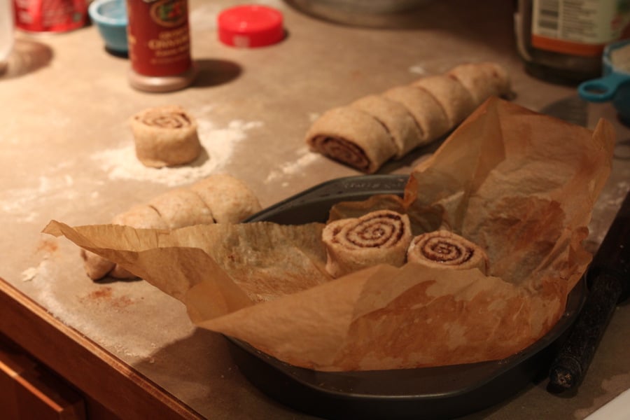 vegan cinnamon rolls  unbaked vegan cinnamon rolls being placed into a round cake pan