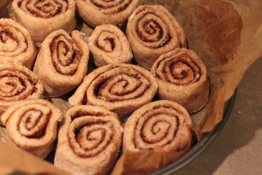 vegan cinnamon rolls  vegan cinnamon rolls proofing in a round parchment-lined cake pan