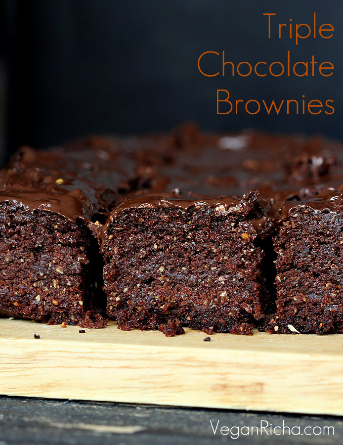 salted caramel brownies side view of Vegan Triple Chocolate Salted Caramel Brownies on a wooden board