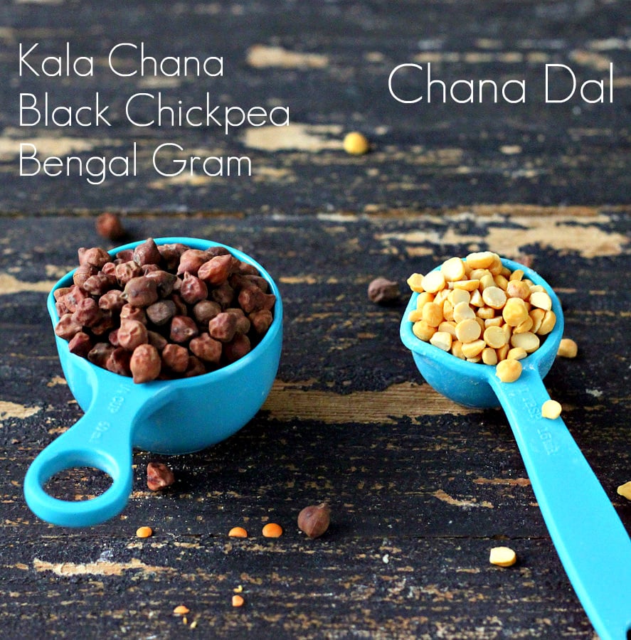 mung dal a small blue plastic measuring cup with black chickpeas next to a teaspoon with split peas