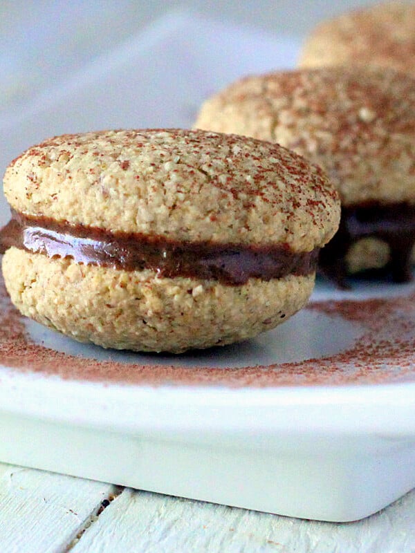 three tiramisu cookies on a white plate, dusted with cocoa powder