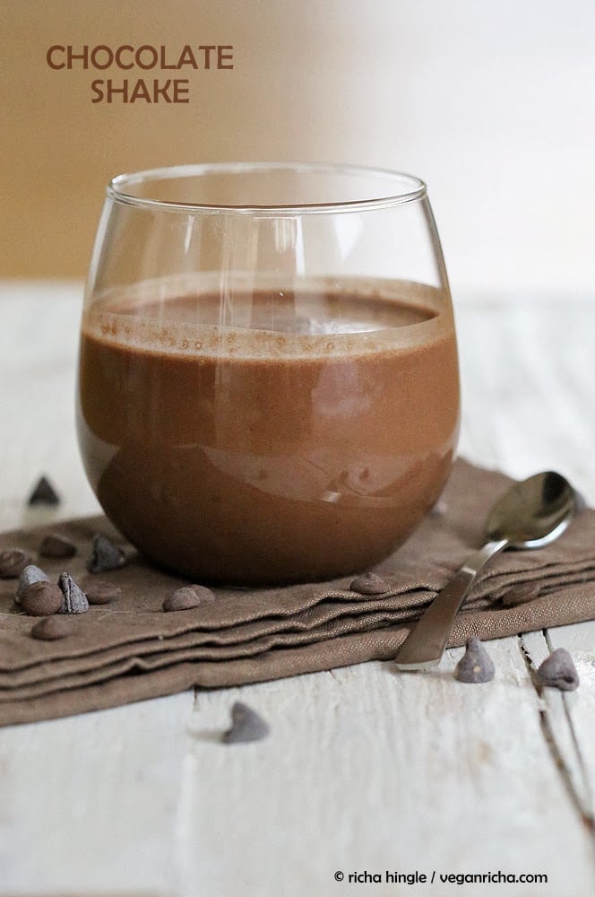 vegan milkshakes side view of a glass of vegan chocolate milkshake with chocolate chips on the side