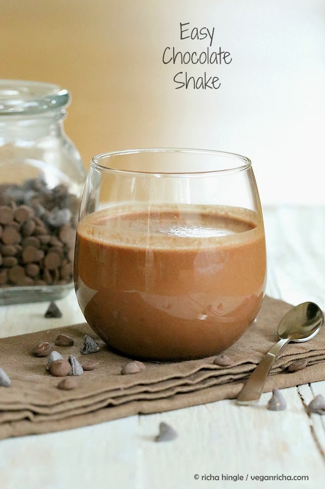 vegan milkshakes side view of a healthy vegan chocolate milkshake with a mason jar with chocolate chips in the background