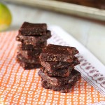No bake chocolate bars stacked on a piece of orange fabric