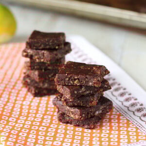 No bake chocolate bars stacked on a piece of orange fabric
