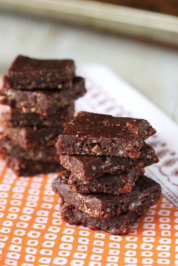 No bake chocolate bars stacked on a piece of orange fabric