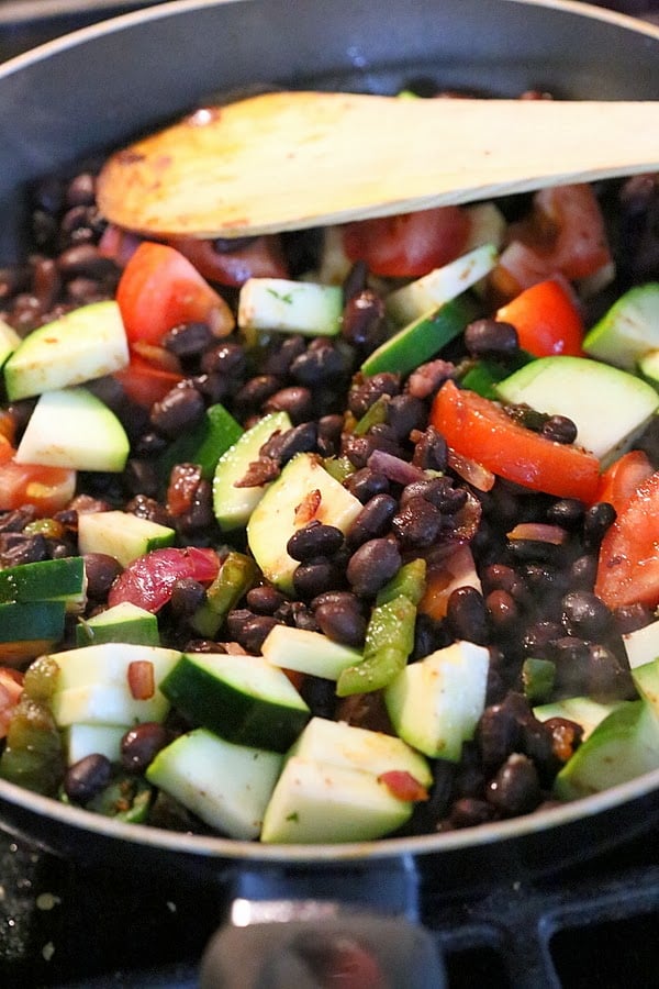vegan wrap recipe  vegetarian filling for a vegan wrap recipe being sauteed in a black pan