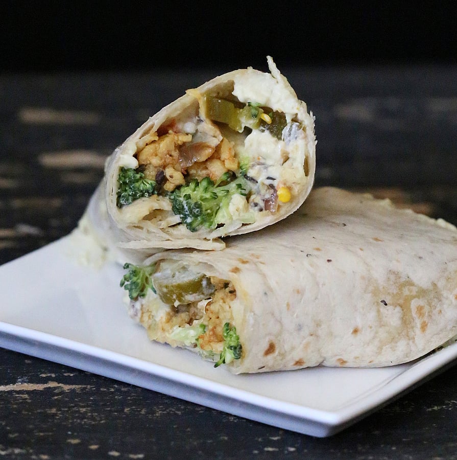 vegan wrap recipe vegan tempeh scramble wraps with cashew cream and broccoli on a square white plate