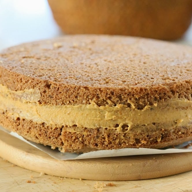 mousse cake vanilla sponge cake being layered with pumpkin mousse to make mousse cake