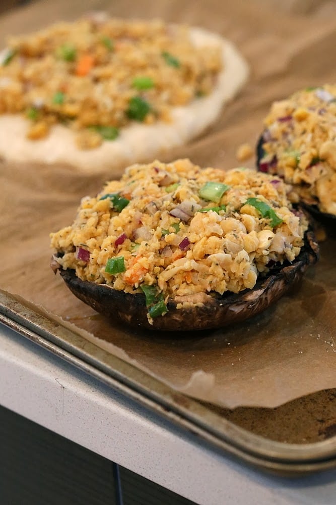 stuffed Portobello mushrooms  Vegan stuffed Portobello mushrooms with chickpea filling lined up on a baking sheet