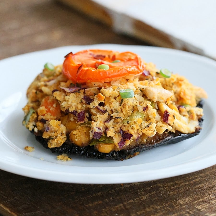 stuffed Portobello mushroom side view of a vegan chickpea stuffed portobello mushroom on a white plate