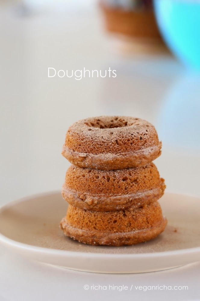 recipe for vegan donuts  three cinnamon sugar-dusted vegan baked sweet potato donuts on a white plate