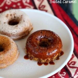 overhead shot of glazed baked vegan sweet potato donuts on a white plate