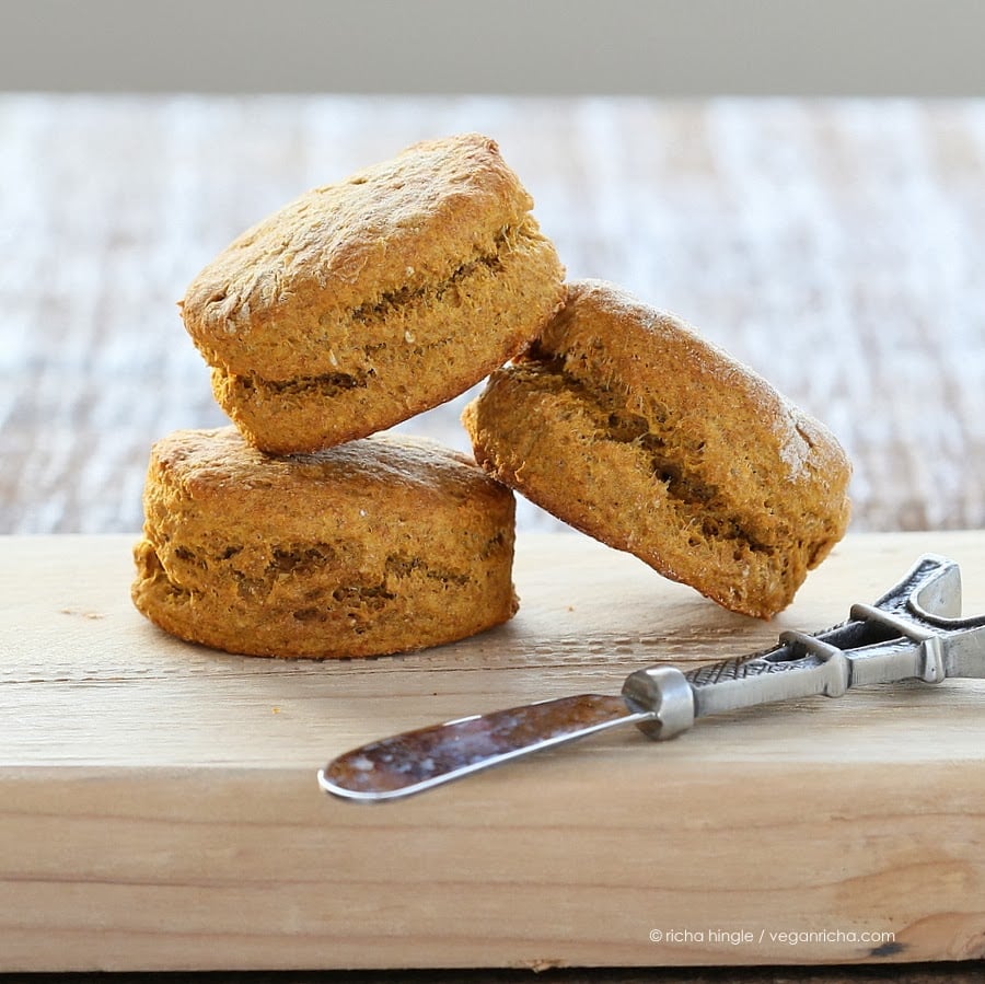 sweet potato biscuits  three vegan sweet potato biscuits made with spelt flour on a wooden board with a butter knife
