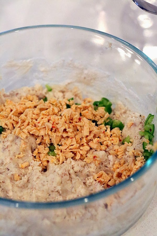 gluten free biscuits recipe  vegan pepper jack shreds and chopped jalapenos being added to gluten-free biscuits dough