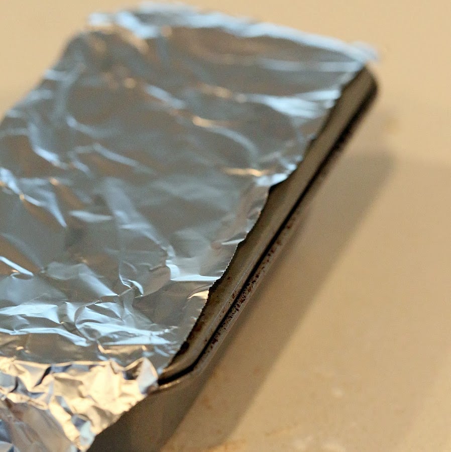 gluten free biscuits recipe aluminum foil being placed over baking pan to prevent gluten-free cheese biscuits from drying out