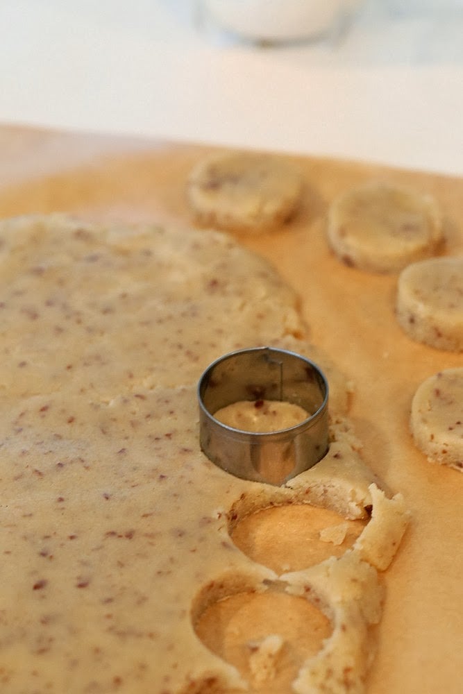 vegan sugar cookies rolled out vegan cookie dough being cut into sugar cookies with a round metal cookie cutter