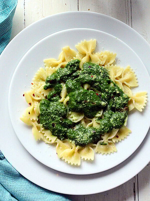 Farfalle with Swiss Chard Pesto served on a white plate with a blue cloth