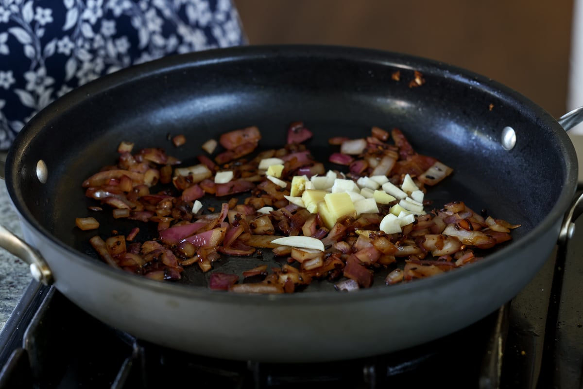 adding ginger and garlic to the pan