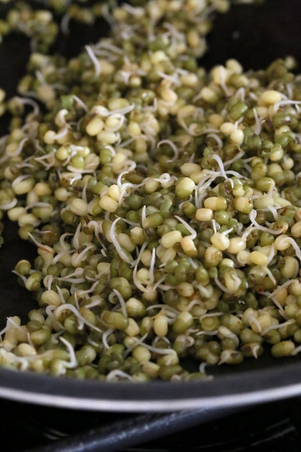 kale salad recipe sprouted mung beans being sauteed in a pan