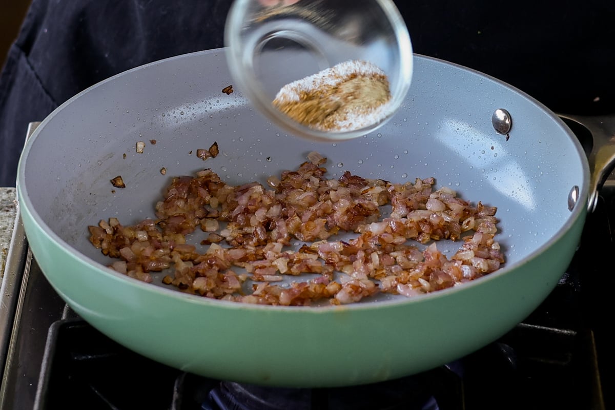 adding salt and spices to cooked onions