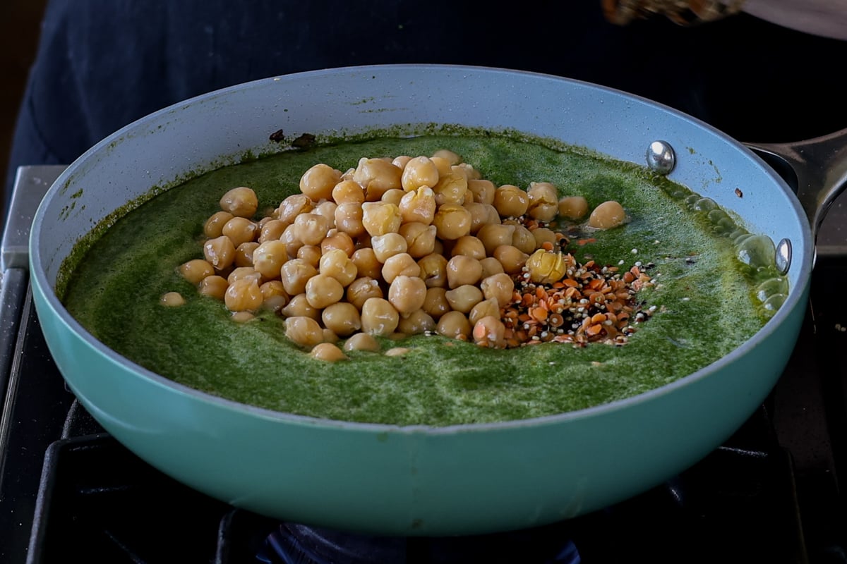 adding lentils, quinoa, and chickpeas to the pan