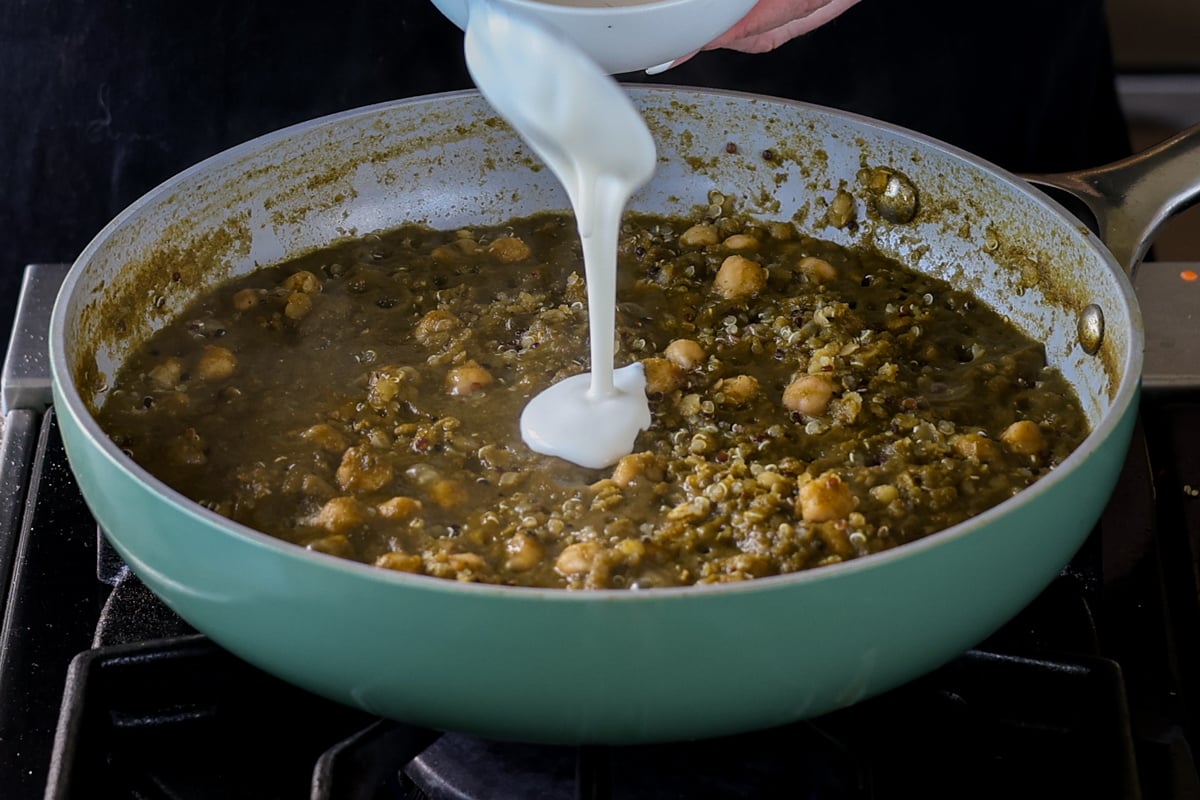 swirling non-dairy cream into the chickpea lentil spinach stew