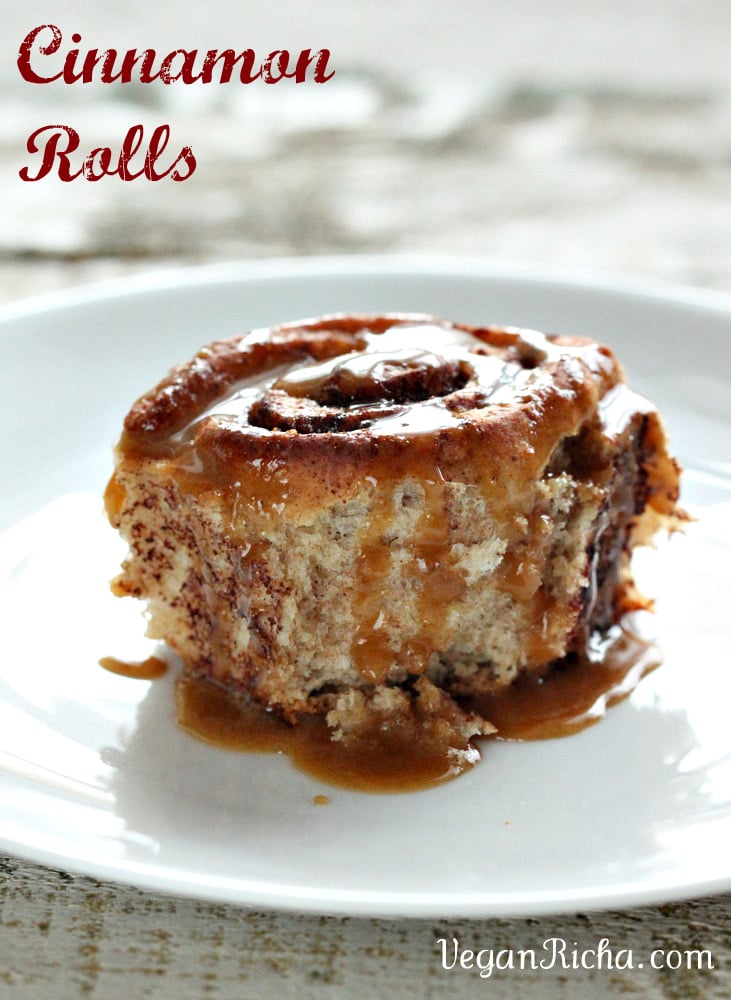 vegan cinnamon rolls side view of a homemade maple-glazed vegan cinnamon roll on a white plate