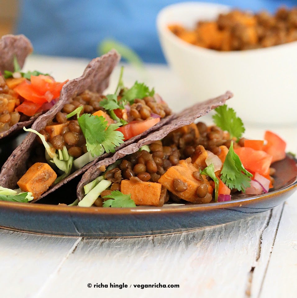 Smoky lentil and sweet potato tacos on a blue plate
