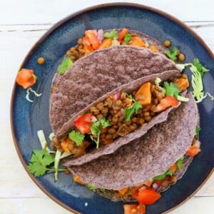 Smoky lentil and sweet potato tacos on a blue plate