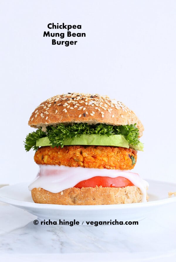 Spicy Chickpea Burger with toppings on sesame seed bun on a white plate