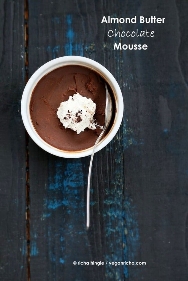 Vegan Chocolate Mousse in a white ramekin with coconut whipped cream and a spoon