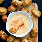 Vegan Pretzel Bites on wooden board with spicy mustard dip in white bowl