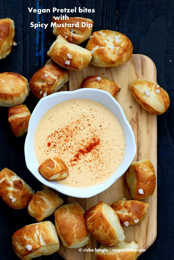Vegan Pretzel Bites on wooden board with spicy mustard dip in white bowl