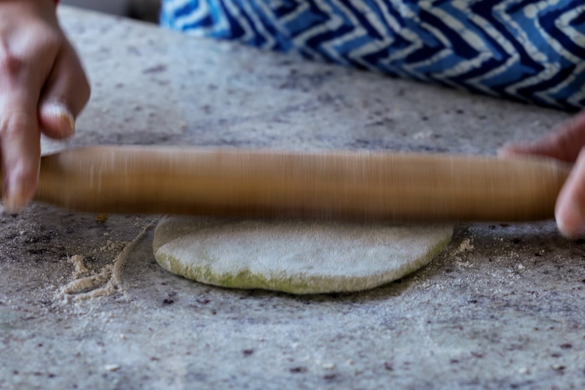 rolling out the stuffed paratha
