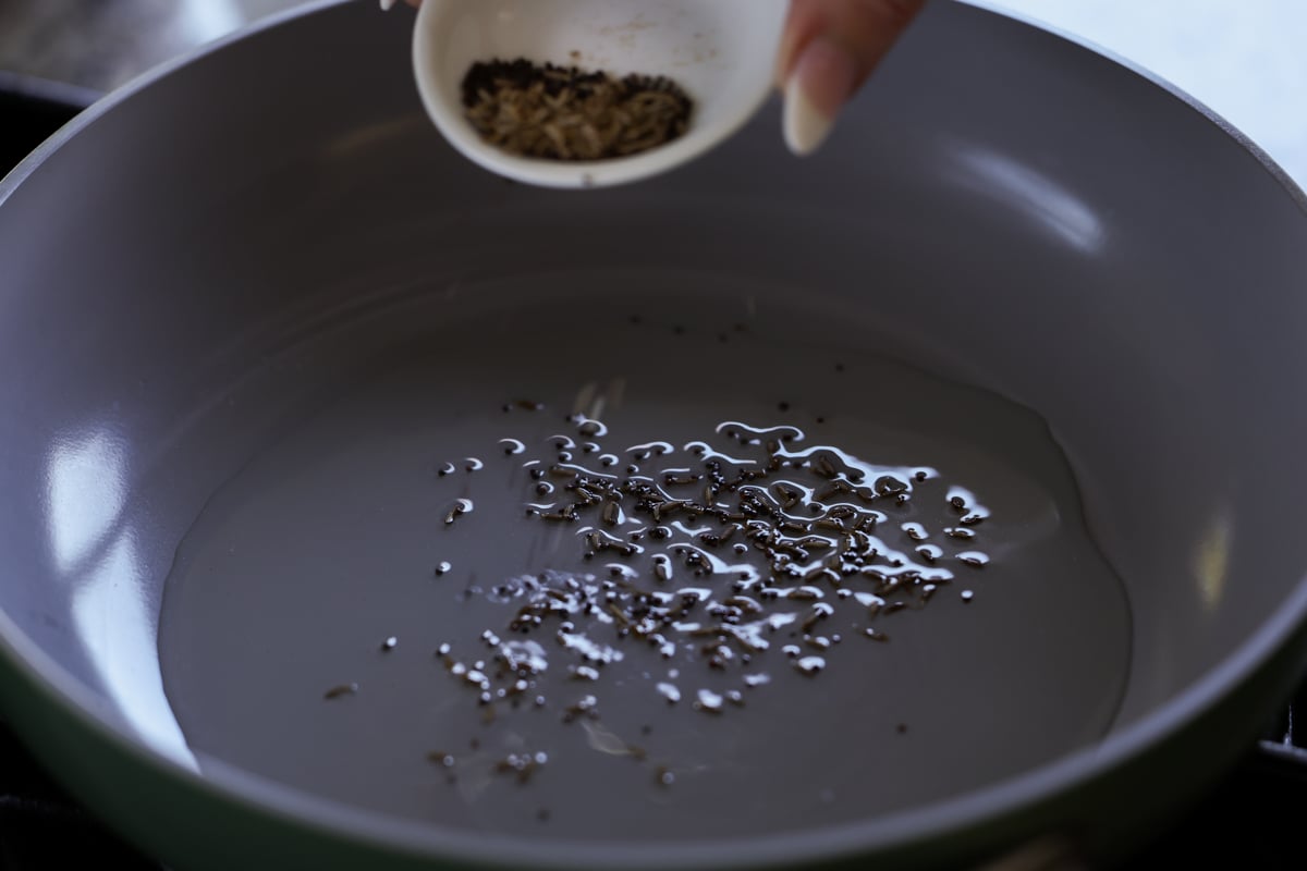 adding whole spices to the pan