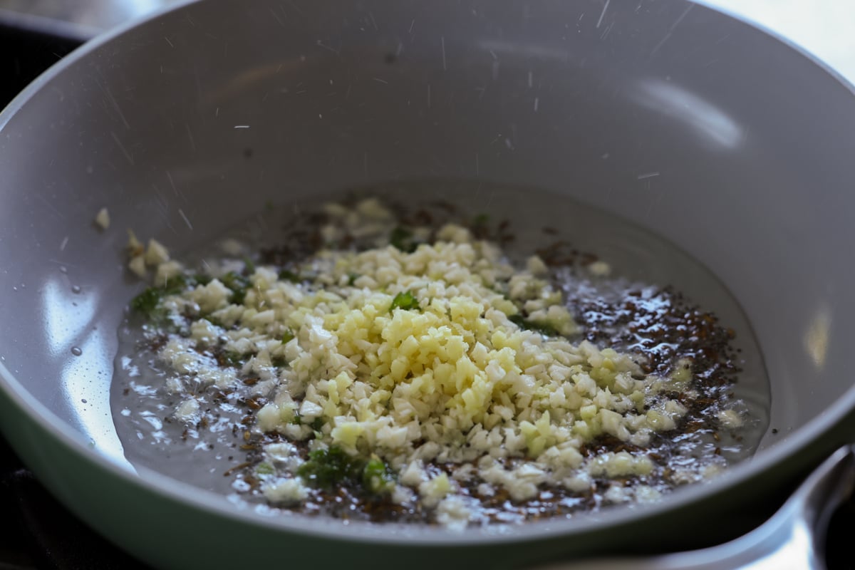 adding garlic to the pan